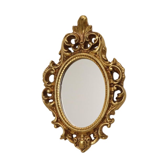 Small vintage crest mirror in classic Baroque style, made of resin gilded with gold leaf; manufactured in France during...
