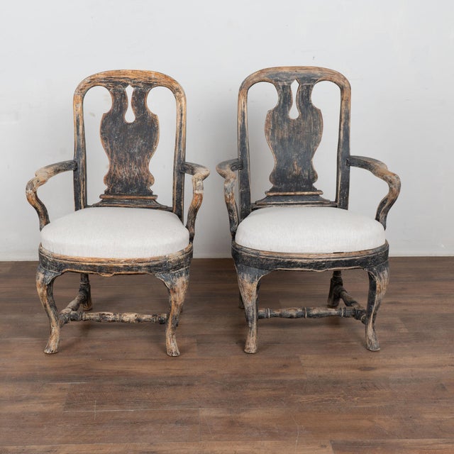 Pair of 19th century Swedish armchairs crafted in pine. The chairs feature an old black painted finish, scraped down...