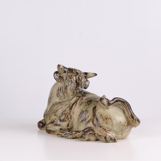 Large reclining bull figure crafted from stoneware by knud kyhn and manufactured by royal copenhagen in 1949. The figure...