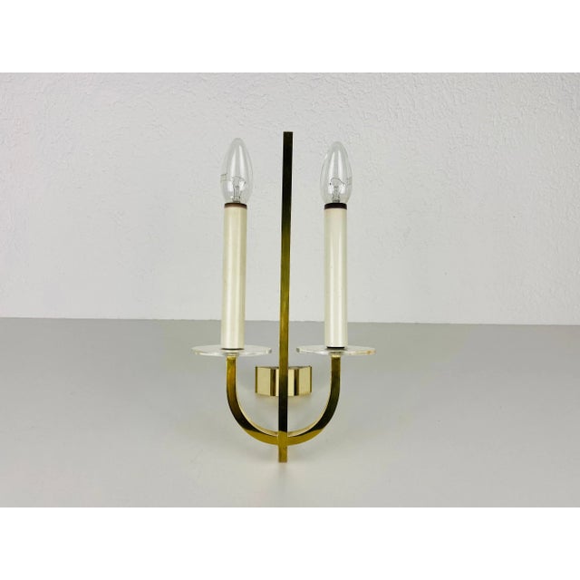 Brass and glass sconces made in Germany in the 1960s. The lamps are in a very good condition. The lights require E14 light...