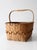 Antique handmade splint basket with a warm honey-toned surface, decorative woven diamond band, and bentwood handle....