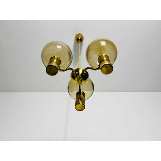 This exquisite brass and glass chandelier, designed by the renowned Swedish designer Hans-Agne Jakobsson in the 1960s, is...