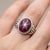 Crafted with a bold yet timeless aesthetic, this elegant ring features a captivating Star Ruby gemstone, renowned for its...