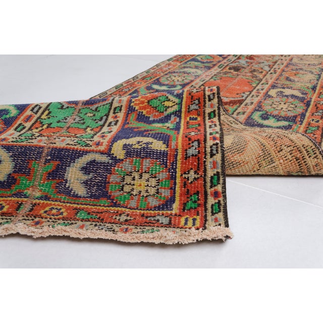 This is a vintage Turkish Oushak rug from the Mid 20th Century. The piece was hand-knotted.