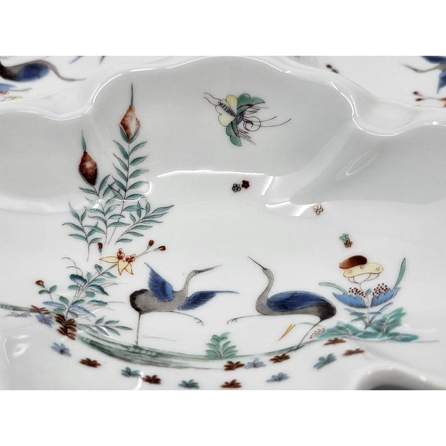 The royal lily porcelain serving dish is a faithful reproduction of the "Kakiemon" decor, emblematic of the Chantilly...