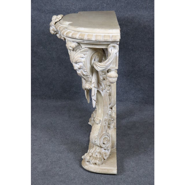 This fine carved Italian console is a striking example of Baroque-inspired artistry, richly decorated with figural masks...