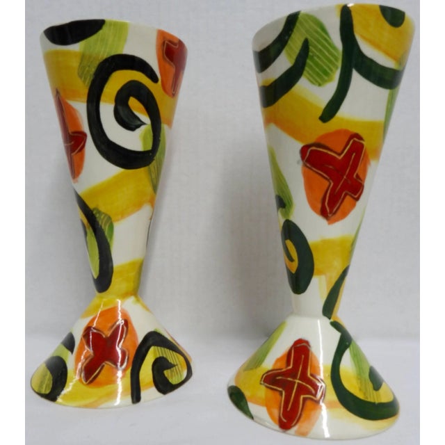 Bold shades of red, orange, yellow and green on white compliment this pair of whimsical goblets by ceramic artist Marilee...