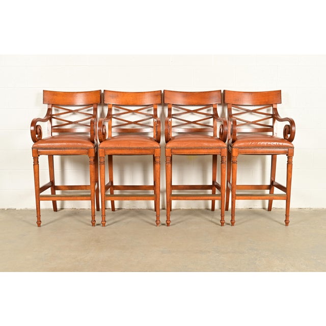 A gorgeous set of four English Regency or Neoclassical style bar stools By Baker Furniture USA, Circa Late 20th Century...