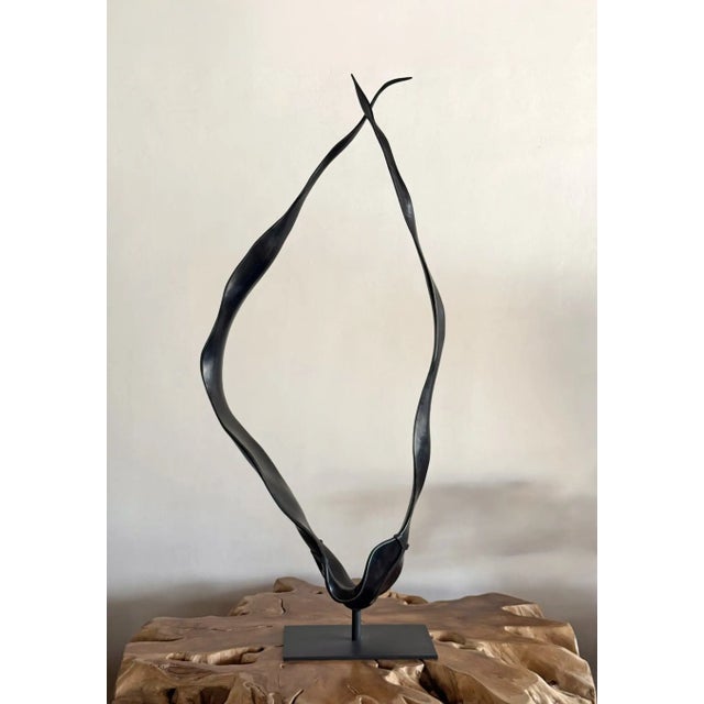 A striking contemporary sculpture carved from a single solid block of suar wood, transformed through an expressive process...