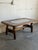 This rectangular coffee table features an inlaid ceramic tile top supported by a sturdy trestle base. Its clean geometric...