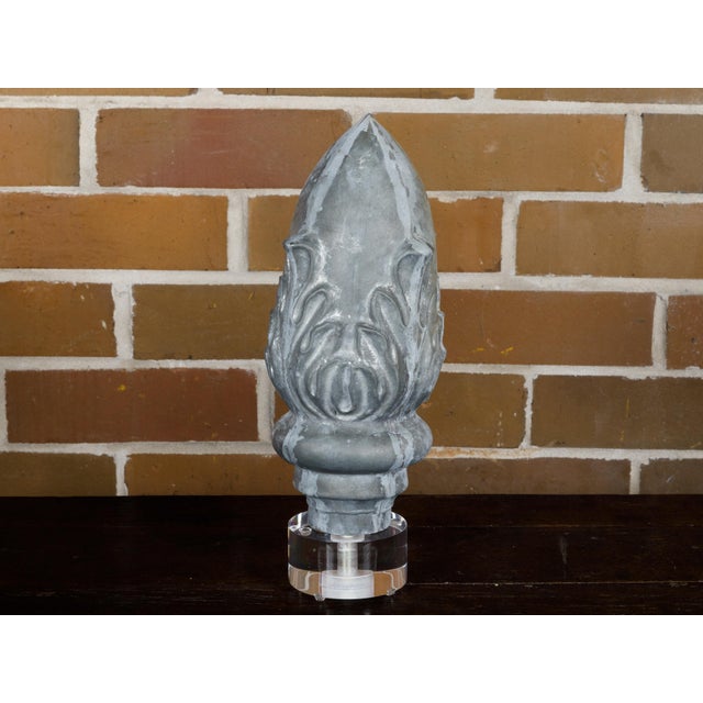 A zinc crowned acorn decorative object from circa 1920 mounted on a circular lucite base. This charming zinc crowned acorn...