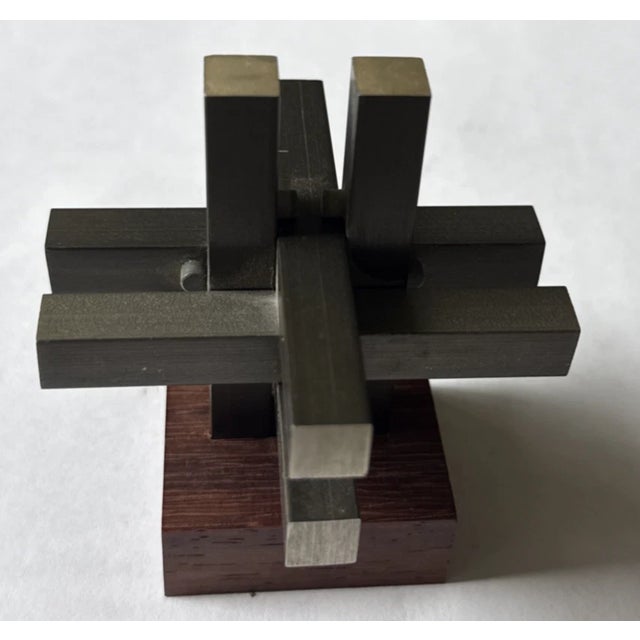The Austin Enterprises Interlocking Aluminum & Rosewood Burr Puzzle is a highly collectible piece of mid-century modernist...