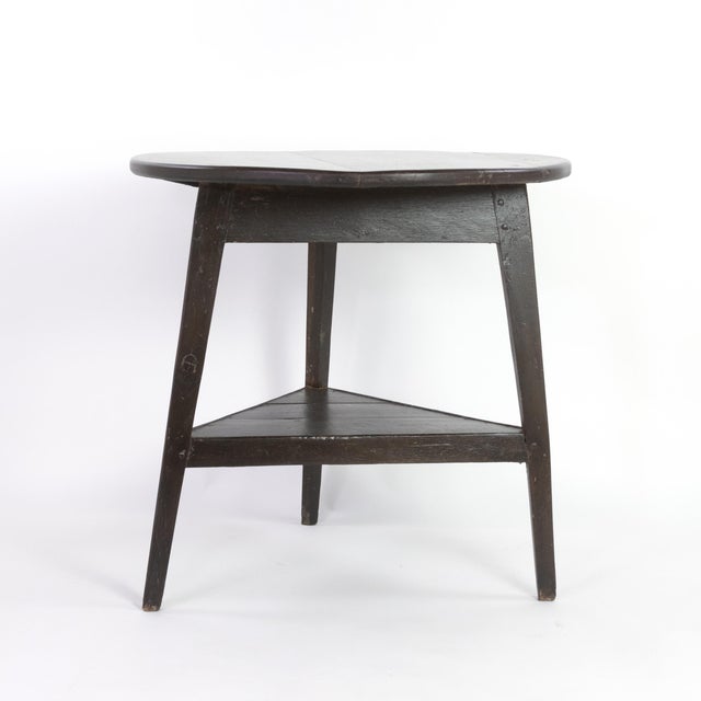 Rustic painted cricket table with triangular lower shelf; English circa 1850. A wonderful painted dark country table with...