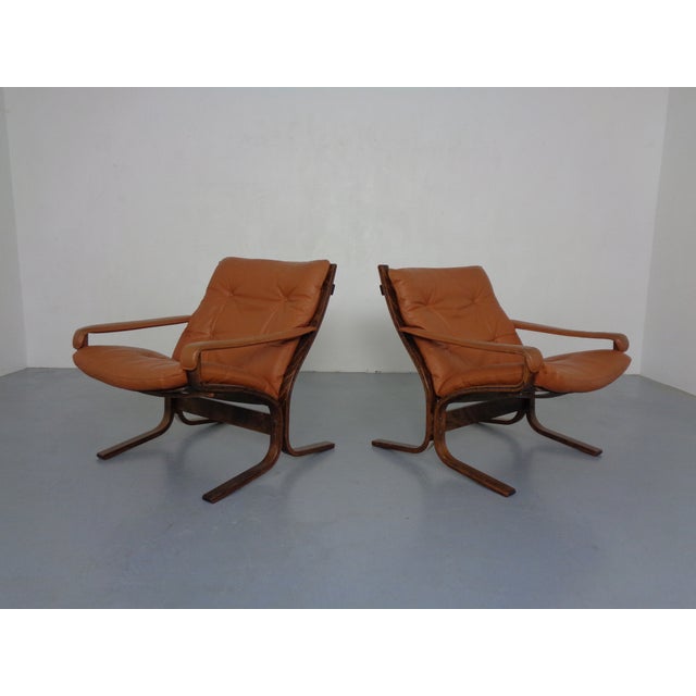 Living room set consisting of two Siesta armchairs in cognac-colored leather and a table. Table dimensions: Height 50 cm,...