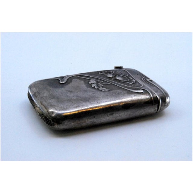 Silver Matchbox with Raised Floral Motifs and Hinged Lid, in Very Good conditions. Designed from 2000 This piece has an...