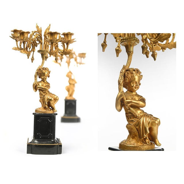 Pair of gilded bronze candelabra. Decorative objects in gilded bronze. It consists of two statuettes of children resting...
