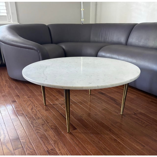 This is a round Carrara marble coffee table, produced in Italy in the 1960s. The stiletto legs are made of burnished...