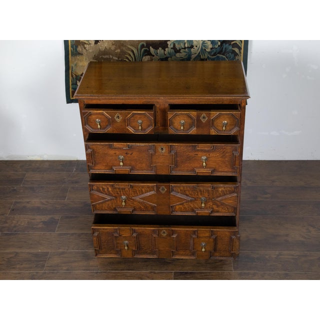An English George III Period two part oak chest from the early 19th century, with geometric front, five drawers and brass...