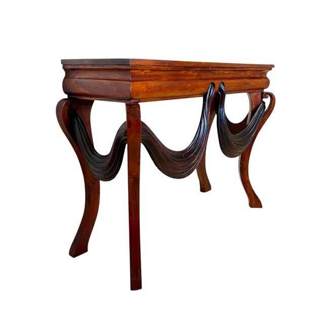 This interesting vintage wood console table features beautifully carved details- Swag drops on the front and sides give...