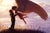 In "Two Worlds," a tender moment unfolds as a couple embraces, with one figure adorned with ethereal wings, symbolizing a...