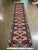 Hand-knotted Persian Kurdish wool runner featuring an elongated field with a repeating central medallion chain set on a...