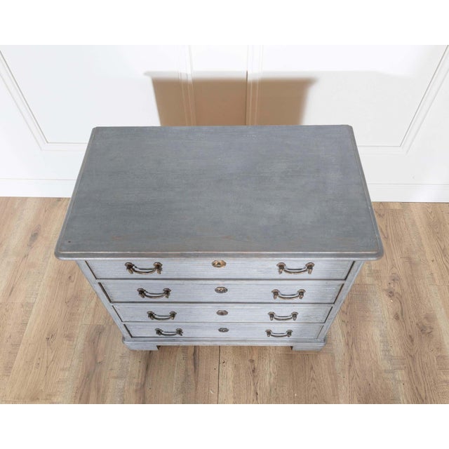 A charming small chest of drawers in the Gustavian style, crafted in Sweden circa 1960. Painted in a soft gray tone, the...