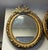 Bring timeless European elegance to your home with this charming oval wall mirror, featuring an ornate gold leaf frame...