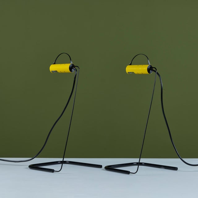 Pair of postmodern table lamps by Vico Magistretti for Oluce, c.1981, Italy. The lamps feature a metal enameled body and...