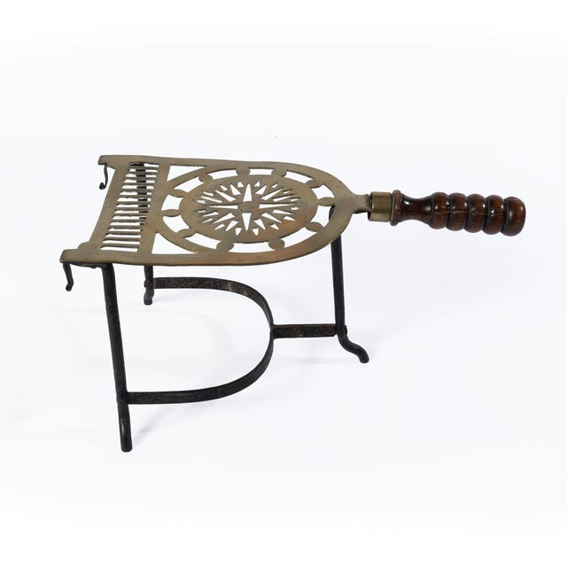 Antique Georgian brass and iron trivet with stunning piercings and a beautiful wooden handle. Great next to a chair to...