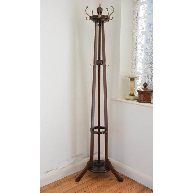 Antique English Arts and Crafts coat stand in solid mahogany, having circular revolving platform fitted with five original...