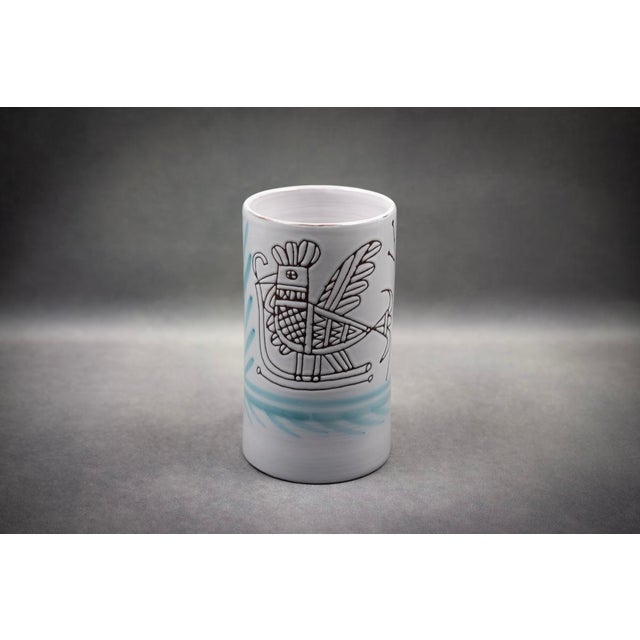 Light-bodied terracotta covered with a glossy white glaze, cylindrical shape with straight walls and an unglazed base. A...