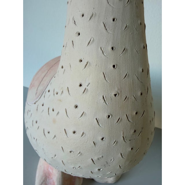 Charming handcrafted ceramic duck sculpture featuring a soft cream finish with subtle blush-pink accents. The piece is...