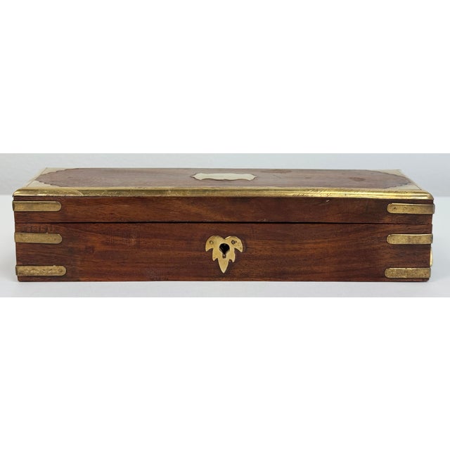 Vintage Mid 20th C wooden box featuring warm, richly grained hardwood and elegant brass detailing. Rectangular form is...