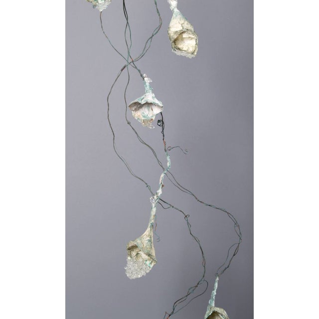 Hanging, patinaed copper wire with handmade paper and cast glass flowers. Item is unmarked, arrives with certificate of...