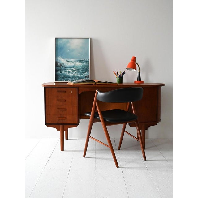 Vintage teak desk with oval structure, four drawers, hinged door and integrated rear bookcase. Scandinavian desk from the...