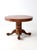 This early 20th century American dining table features a round oak top set on a tiered pedestal base with four claw-footed...