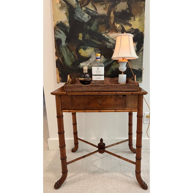 A charming Chinoiserie style faux bamboo side table crafted in the Aesthetic Movement style constructed in turned hardwood...