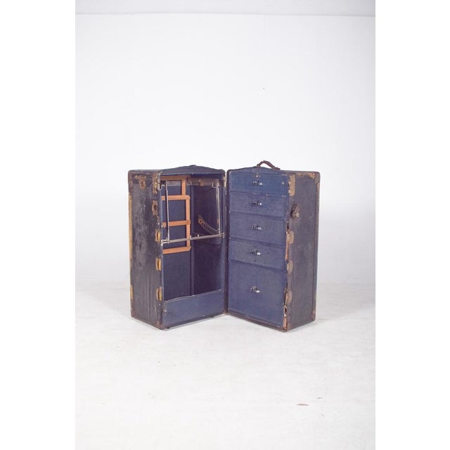 Antique holdall, covered in black leather. Large, covered in black leather, with a wooden structure reinforced by angle...