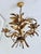 French gilt tole chandelier featuring hand-formed palm and botanical leaves arranged around three scrolling candle arms....