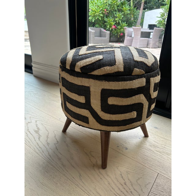 Pair of authentic African Ottomans with three carved accent legs. Each ottoman features a solid internal wooden framework...