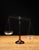 Early 20th-century apothecary balance scale featuring an amber glass pedestal base supporting an ornamental metal balance...