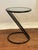 Tubular metal 'Z' shaped frame with a round glass top. Small, compact, minimalist design.Glossy black finish. Circa...