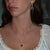 A rhodolite garnet glows in a rich raspberry-purple at the center of this solid 14K white gold pendant, framed by thirty-...