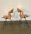 a nice pair of swiveling side chairs with black iron bases, slatted wood seats and rush backs. Designed By Arthur Umanoff....