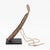 West African Senufo Hand-Forged Iron Rasp Gong, with tan leather strap mounted on ebonized wood base. Overall: 14.25" H x...