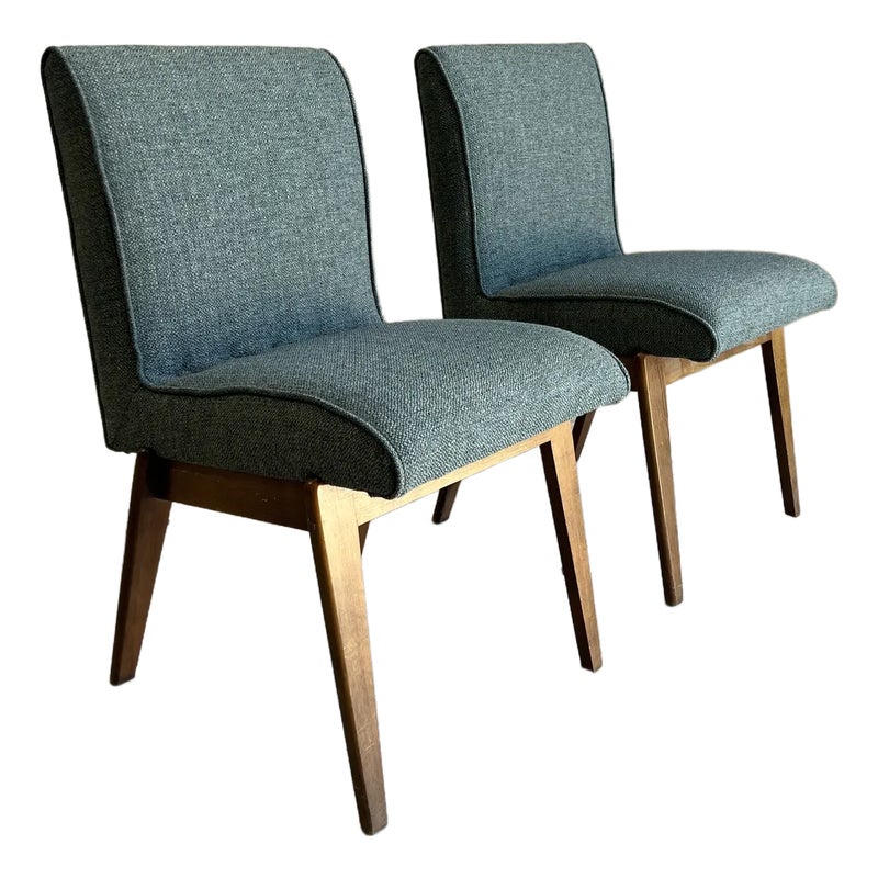 Two gray upholstered chairs with wooden legs