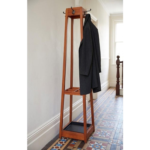 An elegant and well preserved mid century coat and umbrella stand in solid mahogany. This striking hall stand features its...