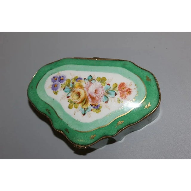 Porcelain box, gilded brass closure, flower decoration on a green and gold background, circa 1940, set in very good condition
