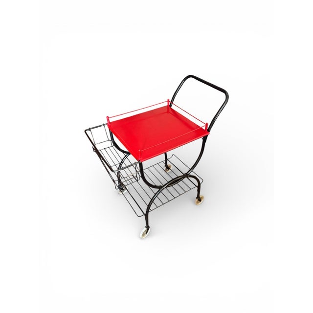 Architectural 1960s modernist bar cart crafted entirely of metal, featuring a sculptural black frame with graceful curved...