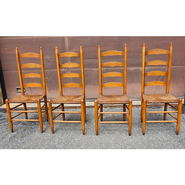 A Set of Four Shaker Style Maple Ladder Back with Rush Seats Dining Chairs Measure 17: in width, 17" in depth and 42" in...